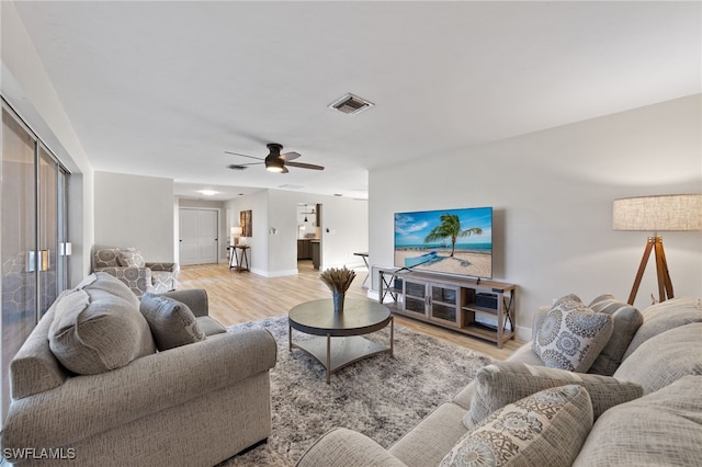 living room with ceiling fan and light wood-type flooring