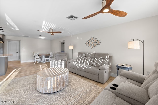 living room with light hardwood / wood-style floors and ceiling fan