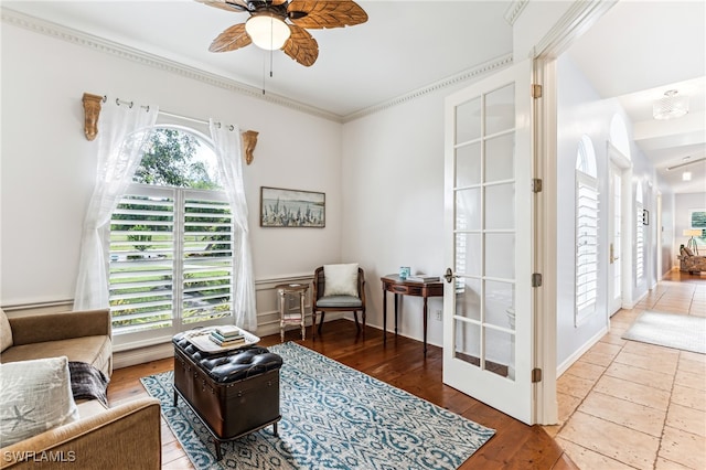 sitting room with wood-type flooring, crown molding, ceiling fan, and french doors