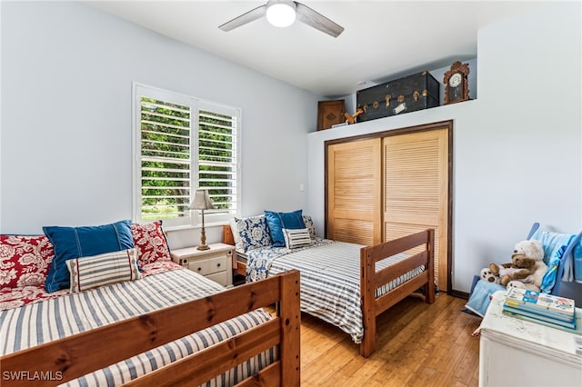 bedroom with ceiling fan, light hardwood / wood-style flooring, and a closet