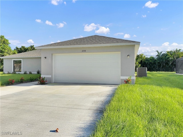 view of front of property with a garage, central AC unit, and a front yard