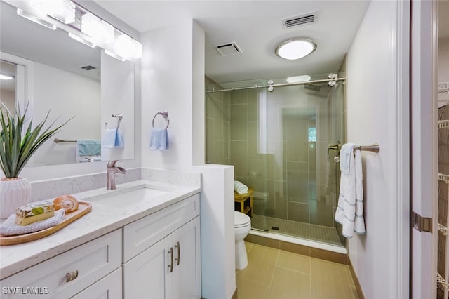 bathroom with vanity, tile patterned floors, toilet, and walk in shower