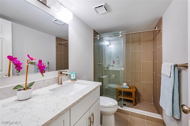 bathroom with a tile shower, vanity, and toilet