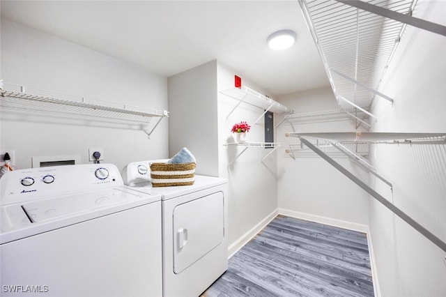 clothes washing area with washing machine and dryer and dark hardwood / wood-style flooring