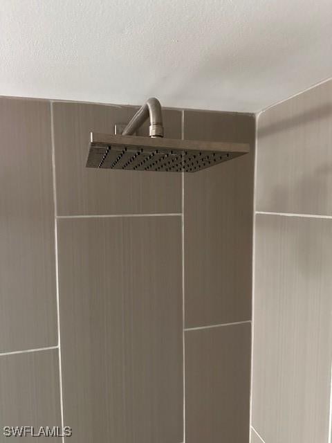 interior details featuring a textured ceiling and walk in shower