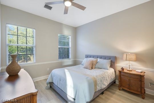 bedroom with light hardwood / wood-style floors and ceiling fan