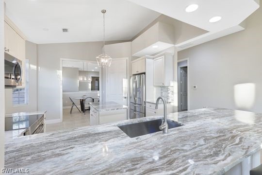 kitchen with kitchen peninsula, white cabinetry, sink, and appliances with stainless steel finishes