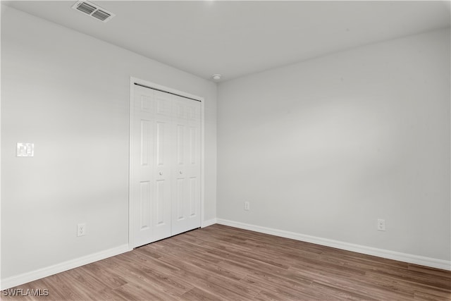 unfurnished bedroom featuring a closet and wood-type flooring