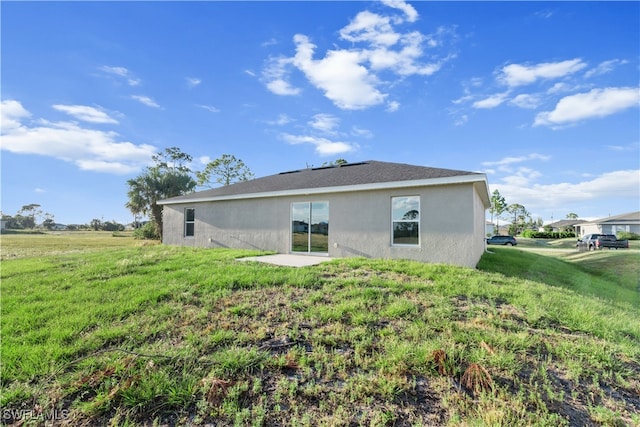 rear view of property featuring a lawn