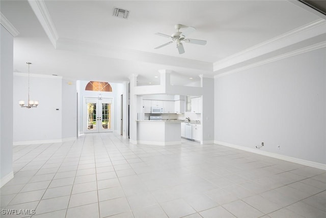 unfurnished living room featuring a tray ceiling, french doors, visible vents, ornamental molding, and ceiling fan with notable chandelier