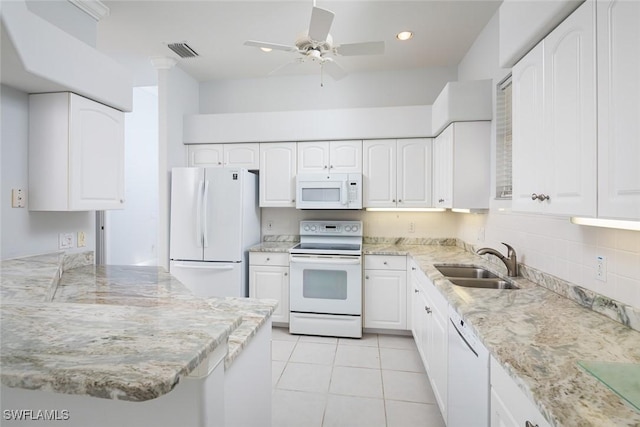 kitchen with white appliances, visible vents, light stone countertops, white cabinetry, and a sink