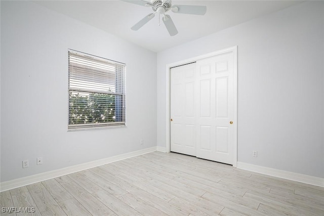 unfurnished bedroom featuring light wood finished floors, a closet, a ceiling fan, and baseboards