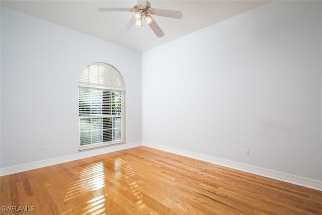 unfurnished room featuring ceiling fan, light wood finished floors, and baseboards