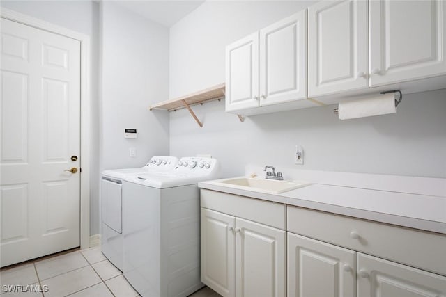 laundry room featuring light tile patterned floors, cabinet space, a sink, and separate washer and dryer