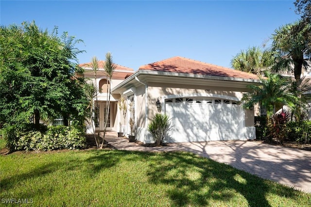 mediterranean / spanish-style house featuring an attached garage, driveway, french doors, stucco siding, and a front yard