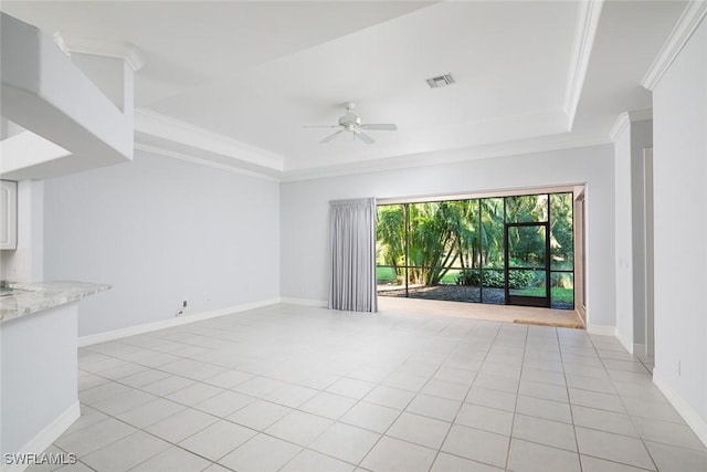 spare room with ornamental molding, a tray ceiling, and visible vents