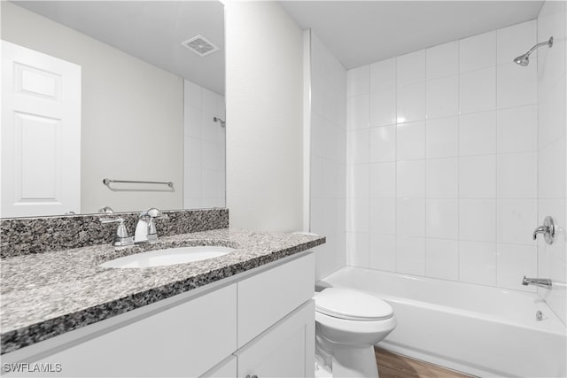 full bathroom with toilet, hardwood / wood-style floors, tiled shower / bath combo, and vanity