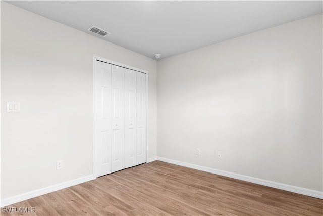 unfurnished bedroom with a closet and light wood-type flooring