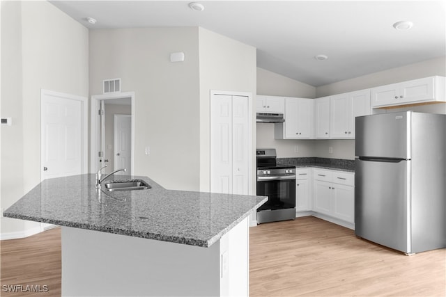 kitchen featuring stainless steel appliances, dark stone counters, sink, light wood-type flooring, and white cabinetry