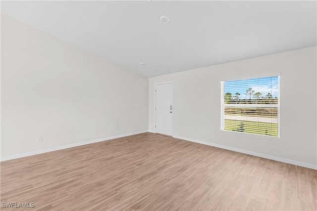 empty room featuring light hardwood / wood-style floors and lofted ceiling