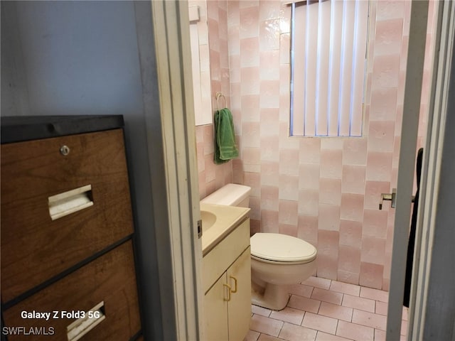 bathroom with vanity, tile walls, tile patterned flooring, and toilet