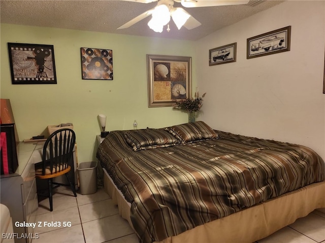 tiled bedroom with a textured ceiling and ceiling fan