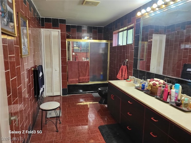 bathroom with tile walls, tasteful backsplash, vanity, and toilet