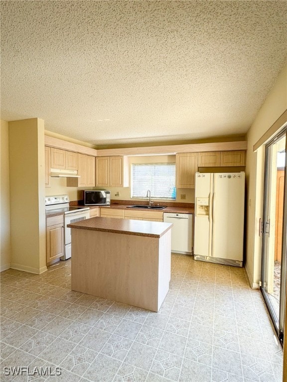 kitchen featuring a center island, white appliances, sink, a textured ceiling, and light brown cabinetry