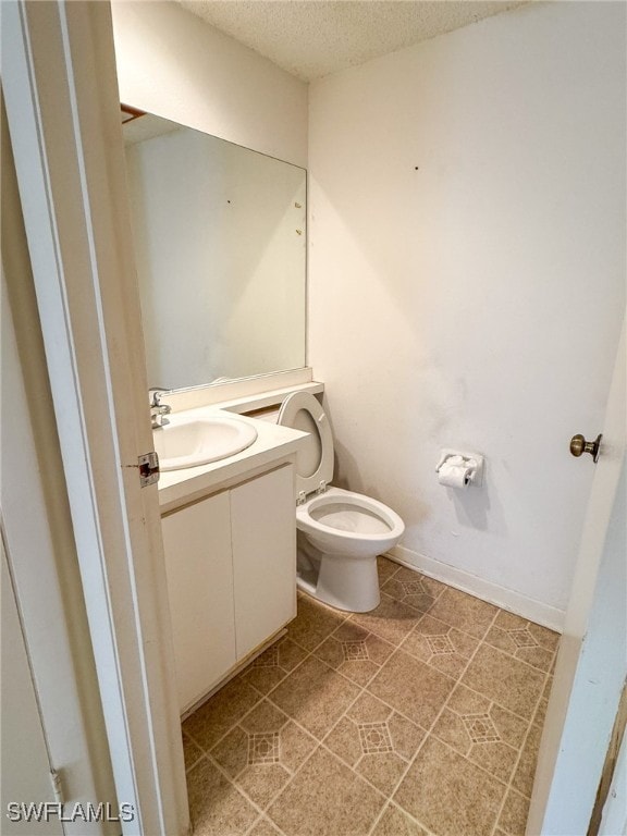 bathroom with vanity, a textured ceiling, toilet, and tile patterned flooring