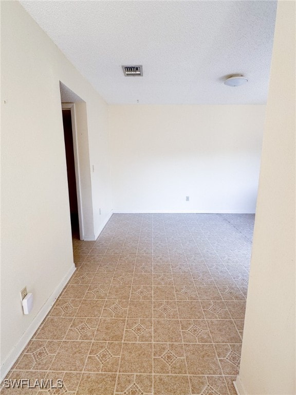 unfurnished room featuring a textured ceiling