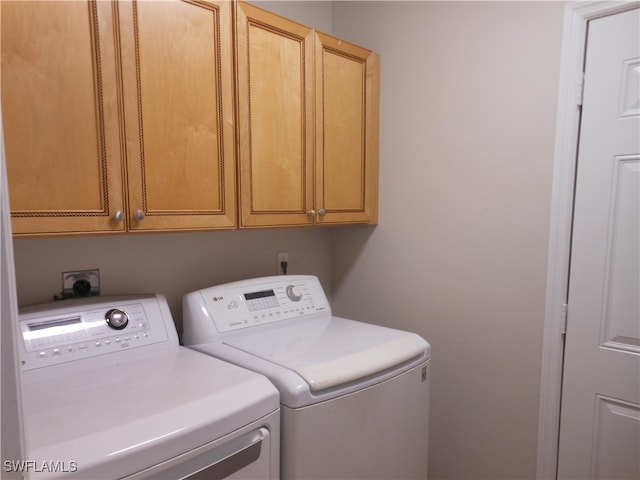 washroom with separate washer and dryer and cabinets