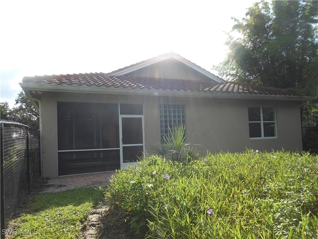 back of property with a sunroom