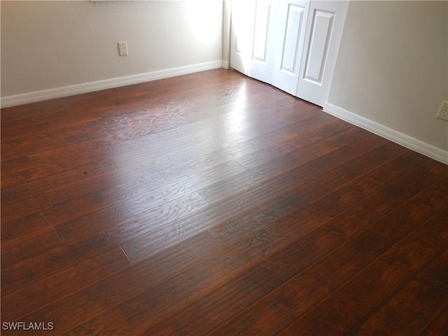 unfurnished room with dark hardwood / wood-style floors