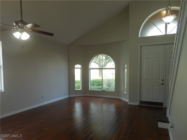 foyer entrance featuring ceiling fan, dark wood-type flooring, and high vaulted ceiling