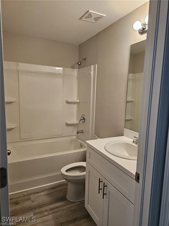 full bathroom with tub / shower combination, vanity, toilet, and wood-type flooring