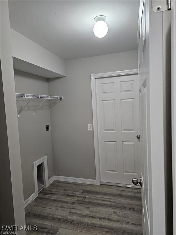 laundry room featuring a fireplace, dark hardwood / wood-style flooring, and electric dryer hookup