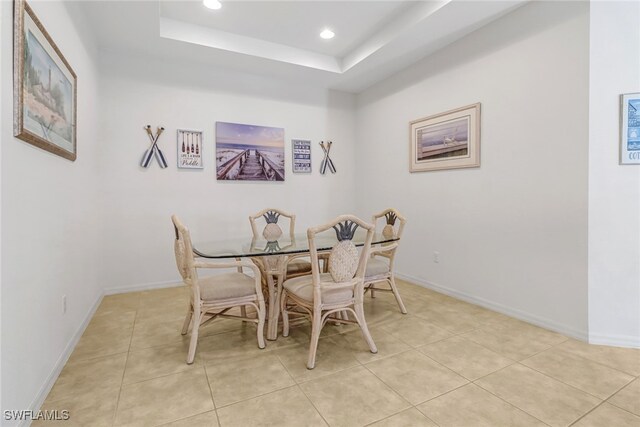 dining space featuring light tile patterned floors, baseboards, a tray ceiling, and recessed lighting