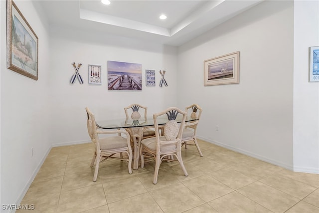 dining room with recessed lighting, a raised ceiling, light tile patterned floors, and baseboards