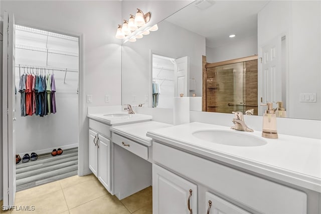 full bath with tile patterned flooring, a sink, a walk in closet, and a shower stall