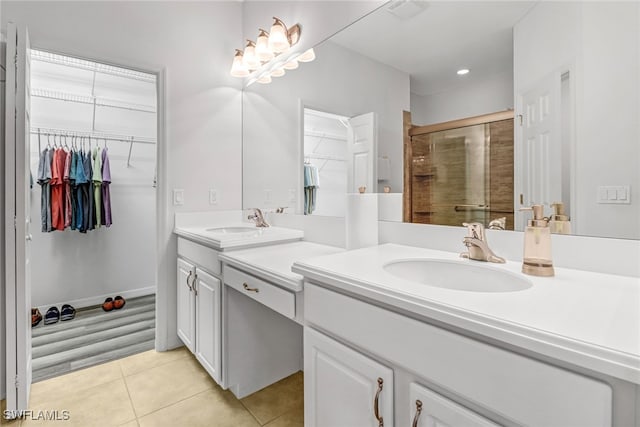 bathroom featuring tile patterned flooring, a shower stall, a walk in closet, double vanity, and recessed lighting