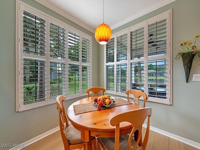 dining space with crown molding and light hardwood / wood-style floors