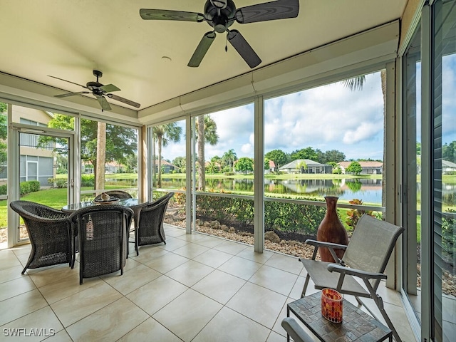 sunroom / solarium featuring a water view, ceiling fan, and plenty of natural light