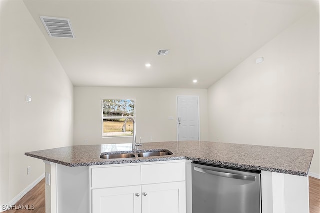 kitchen featuring an island with sink, sink, light wood-type flooring, stainless steel dishwasher, and white cabinetry