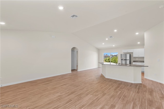 unfurnished living room featuring light hardwood / wood-style floors and lofted ceiling