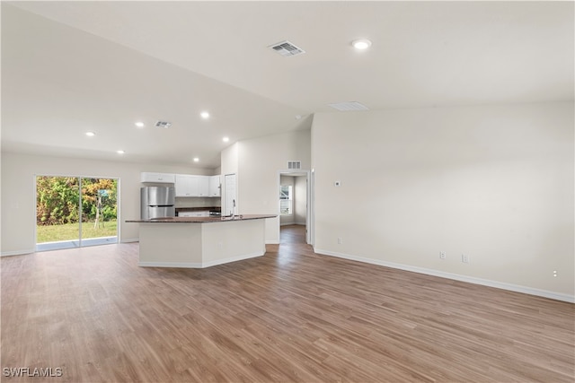 kitchen with white cabinetry, light hardwood / wood-style flooring, and stainless steel fridge