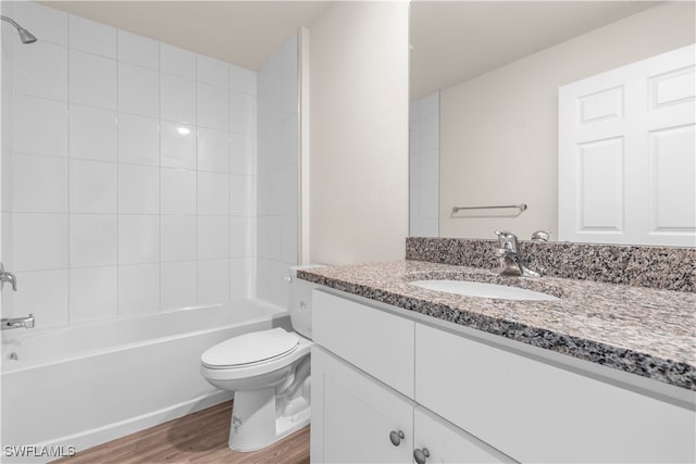 full bathroom featuring vanity, tiled shower / bath combo, wood-type flooring, and toilet