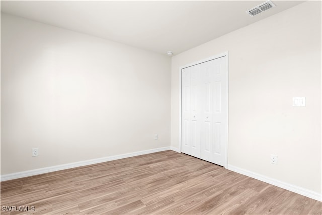 unfurnished bedroom with a closet and light wood-type flooring