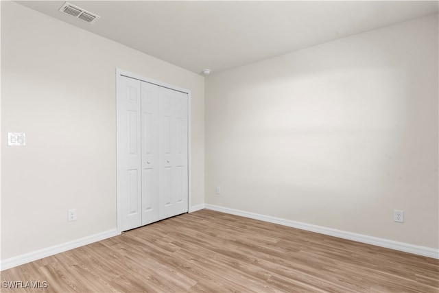 unfurnished bedroom featuring a closet and light wood-type flooring