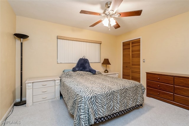 bedroom featuring ceiling fan, a closet, and light carpet