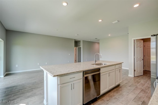 kitchen featuring light wood-type flooring, dishwasher, sink, an island with sink, and white cabinetry